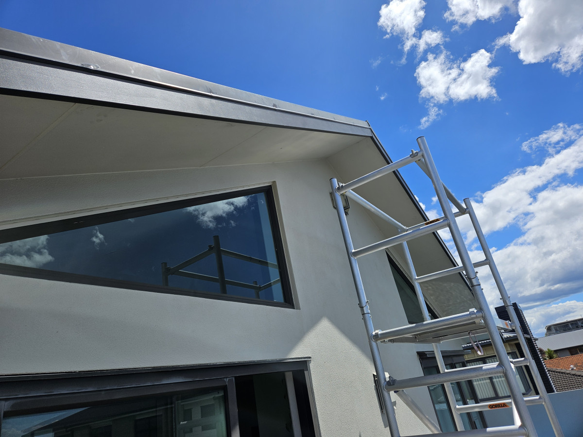 Modern house exterior with triangular gable glazing and scaffold